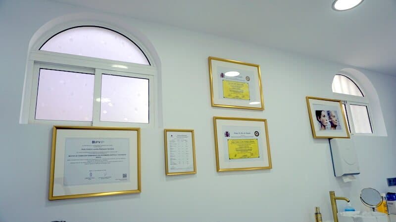 Pared con las titulaciones y acreditaciones de la clínica